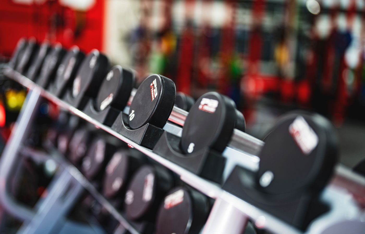 Close-up view of dumbbells in a modern gym setting, emphasizing fitness and training.