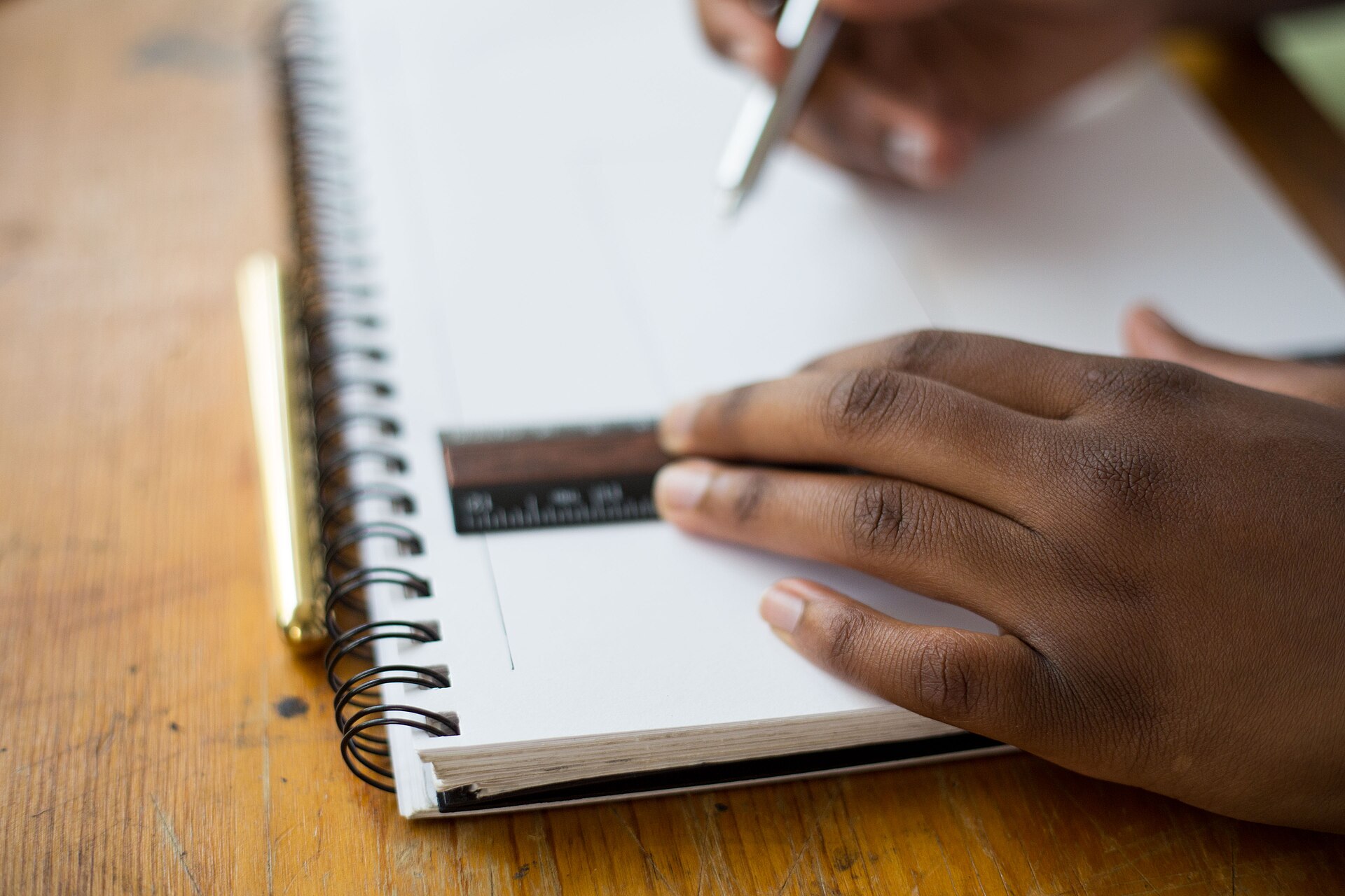 Person writing carefully in a notebook