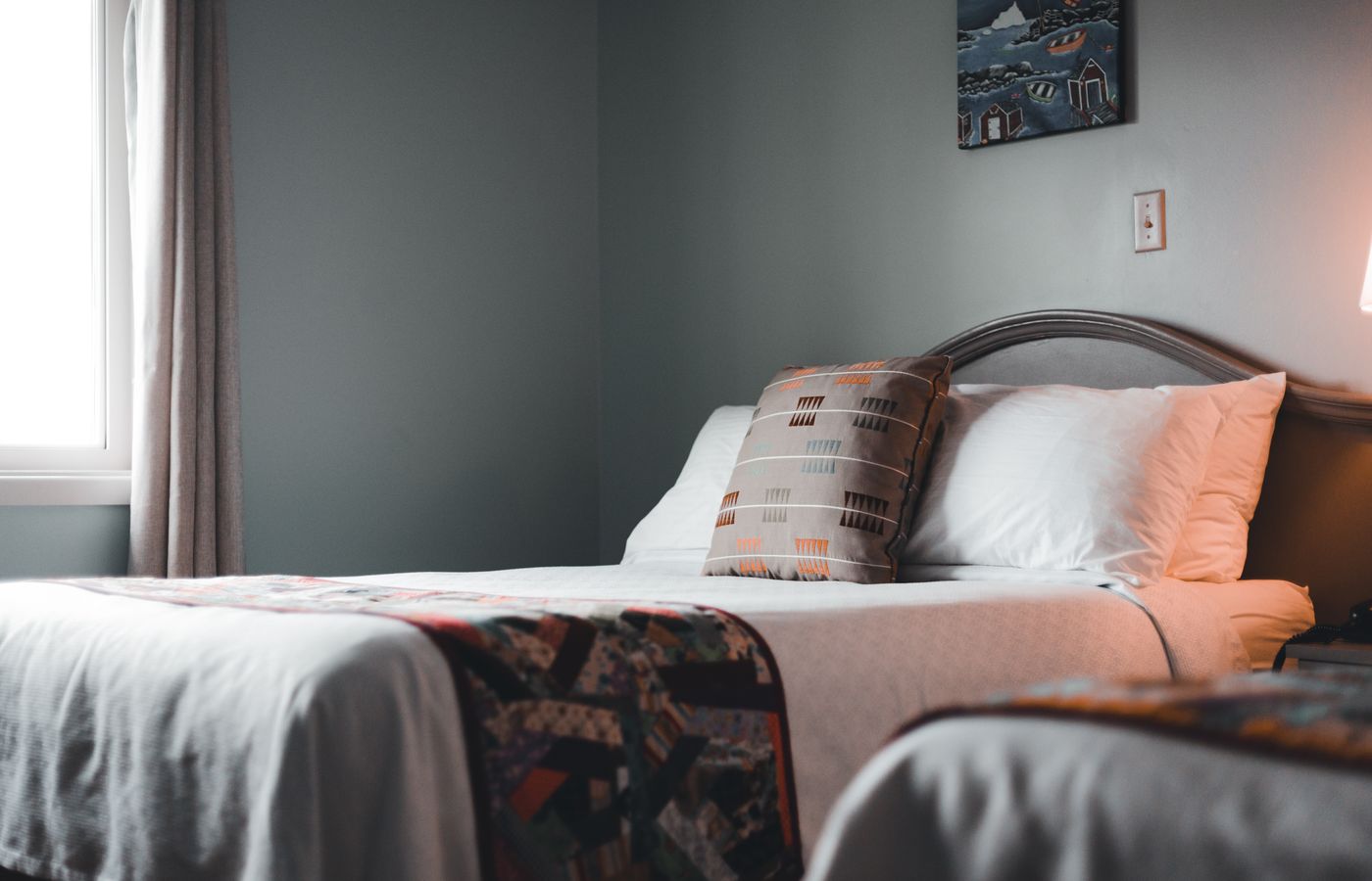Inviting hotel room interior with a neatly arranged bed and soft lighting.