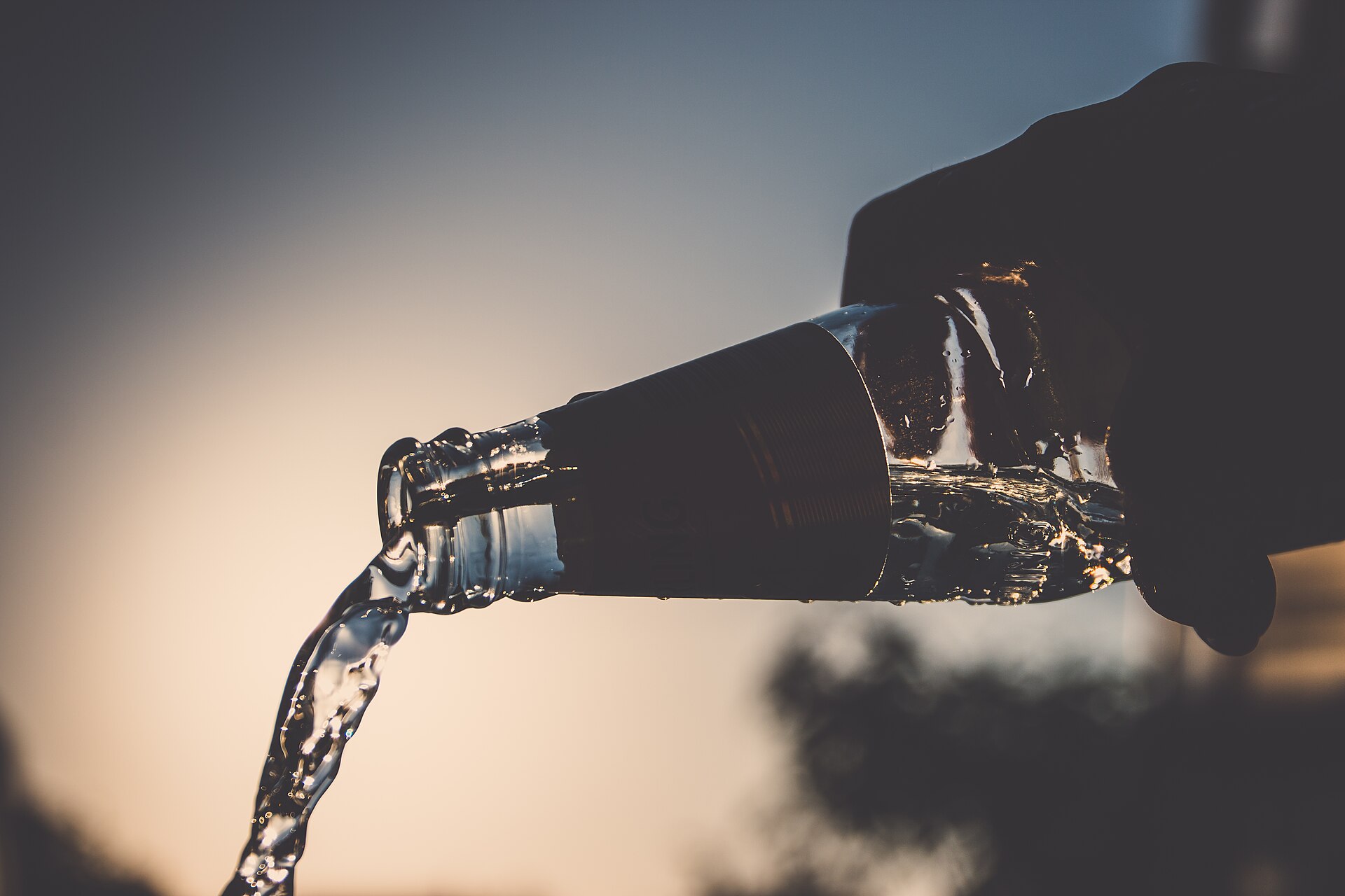 Water pouring from a reusable glass bottle